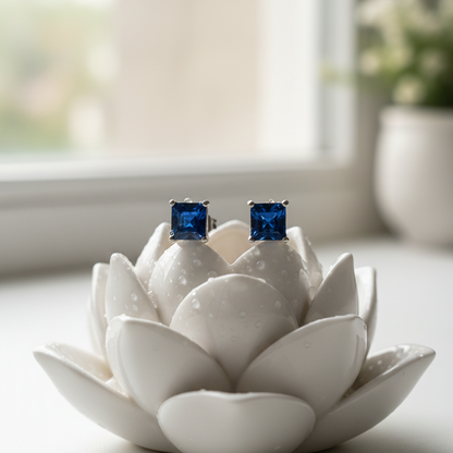 Blue square stud earrings on a white ceramic lotus flower