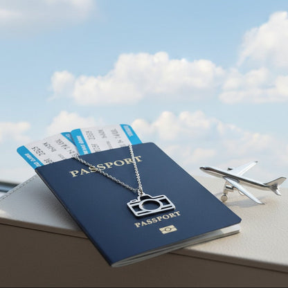 Passport, airplane tickets, and a necklace with a camera pendant on a table with a sky background